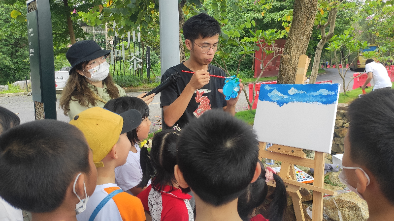 绘画老师来到茶田为参加写生的孩子们讲解如何观察和构图.jpg